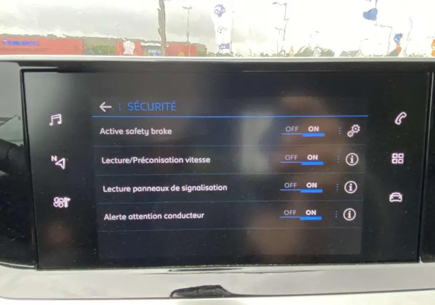 Écran tactile intérieur affichant les réglages de sécurité activés sur Peugeot 208 noire métallisée 2023.