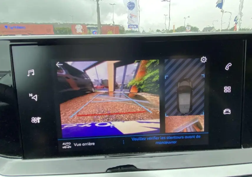 Écran tactile du Peugeot 208 2023 montrant la caméra de recul avec aide graphique au stationnement arrière.