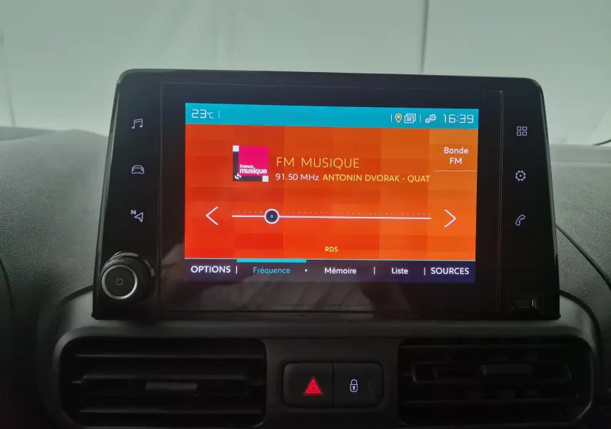 Écran tactile central du tableau de bord du Citroën Berlingo blanc, affichant la radio FM avec station France Musique.
