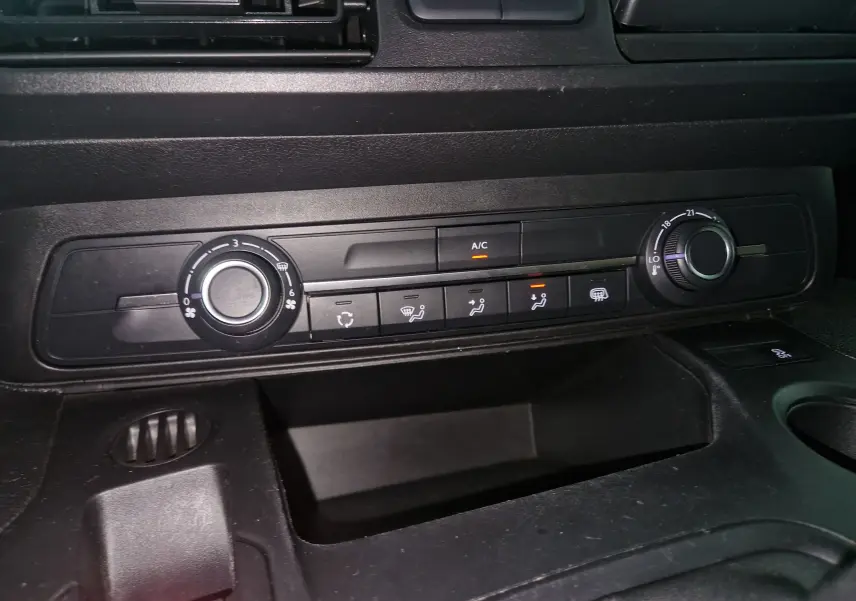 Vue rapprochée du tableau de bord noir du Citroën Berlingo 2019 montrant les commandes de climatisation et ventilation.