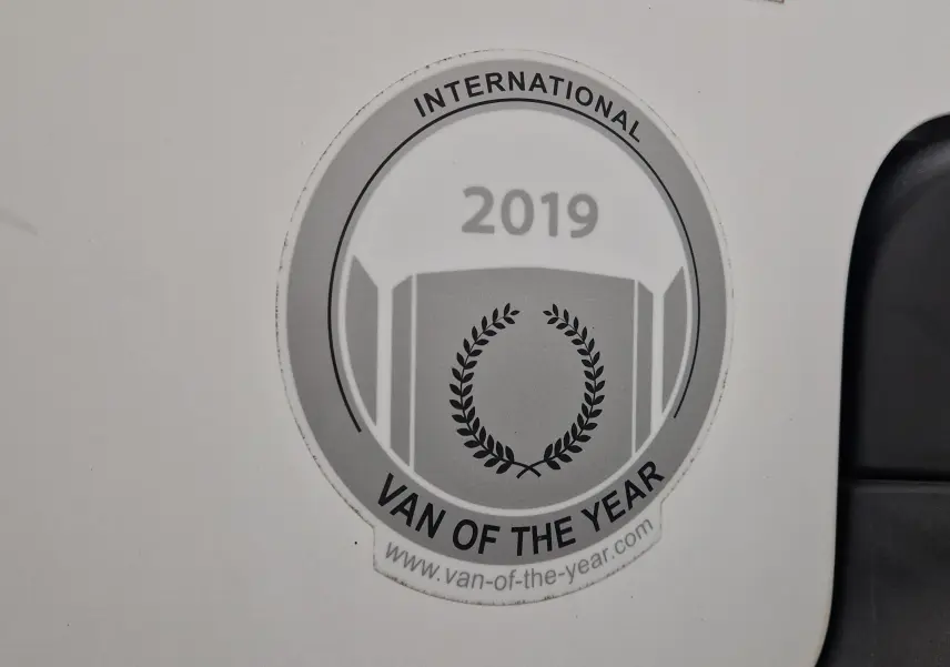 Gros plan sur l'autocollant "International Van of the Year 2019" apposé sur la porte blanche d'un Citroën Berlingo.