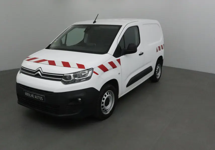 Vue 3/4 avant droit d'un Citroën Berlingo blanc 2019 avec bandes rouges diagonales sur la carrosserie.