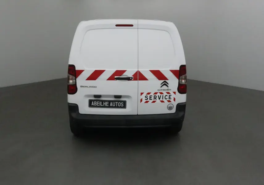 Vue arrière d'un Citroën Berlingo blanc de 2019 avec bandes rouges diagonales et logo "Service" sur la porte.