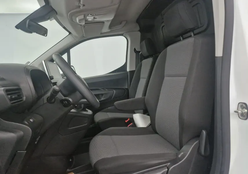 Vue intérieure côté conducteur du Citroën Berlingo blanc 2019, montrant les sièges avant et le tableau de bord simple.