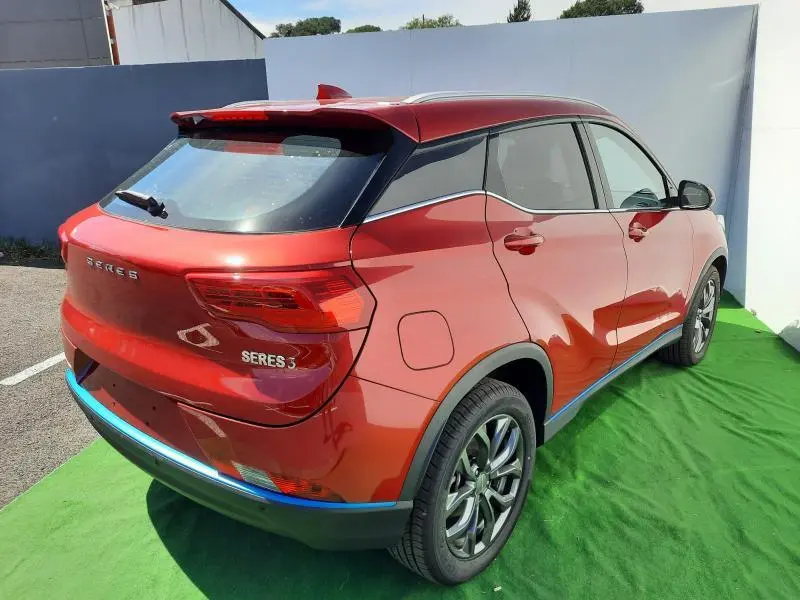 Vue 3/4 arrière droite du SUV électrique SERES 3 rouge carmin avec toit noir et jantes alliage.