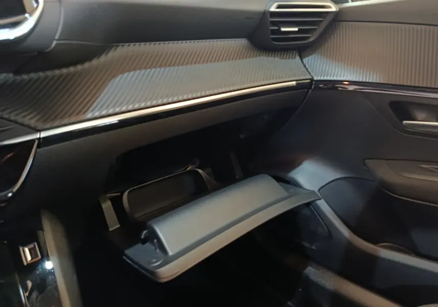 Intérieur Peugeot 208 Electrique blanc 2020, vue côté passager sur boîte à gants ouverte et tableau de bord noir.