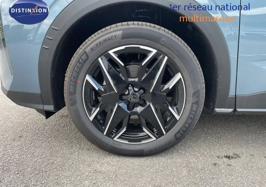 Gros plan sur la roue avant gauche du Peugeot 3008 Hybrid 2025 en bleu Ingaro Métal avec jante noire et argentée.