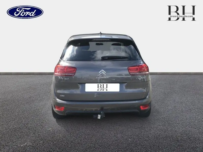 Vue arrière d'une Citroën C4 Picasso gris Shark avec attelage et feux arrière rouges visibles.
