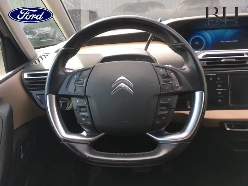 Volant cuir multifonction vu de face dans l'habitacle beige d'une Citroën C4 Picasso Gris Shark de 2016