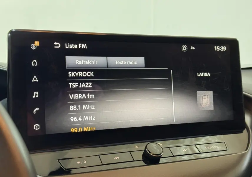 Écran tactile central du Nissan Juke gris clair 2025 affichant la liste des stations radio FM