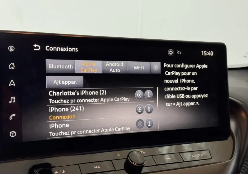 Gros plan sur l’écran tactile central du Nissan Juke 2025 gris clair affichant les options de connexion Apple CarPlay et Bluetooth.