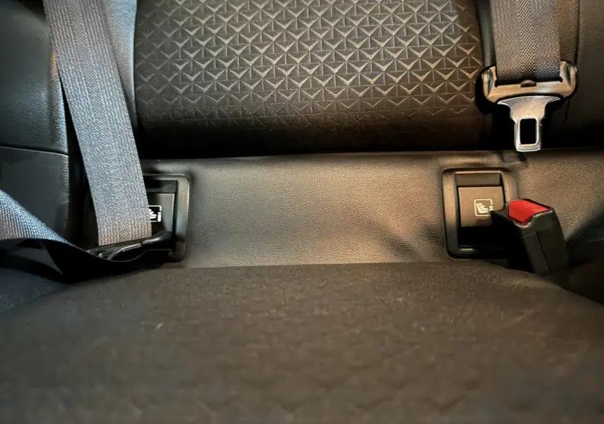 Gros plan sur la banquette arrière noire du Nissan Juke 2025 avec ceintures de sécurité et fixations Isofix visibles.