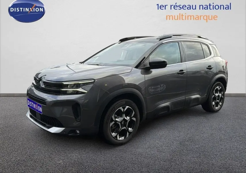 Vue de profil côté gauche du Citroën C5 Aircross Hybrid gris platinium avec jantes bi-ton et barres de toit.