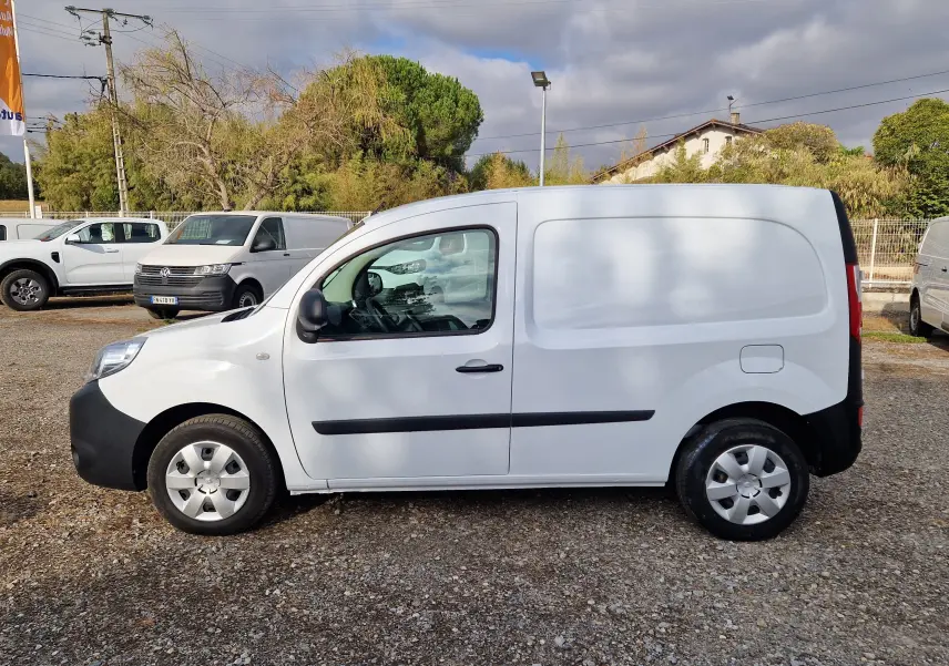 Renault Kangoo blanc vue de profil côté gauche, fourgonnette utilitaire avec protections noires sur les portières.