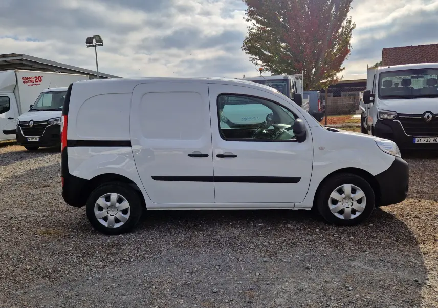 Profil côté droit d’un Renault Kangoo blanc 2021 utilitaire avec protections noires et jantes argentées sur un parking.