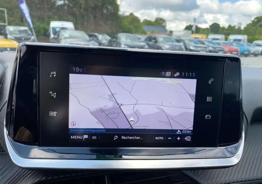 Écran tactile 7 pouces affichant la navigation 3D dans l'habitacle de la Peugeot 208 noire, vue de face.