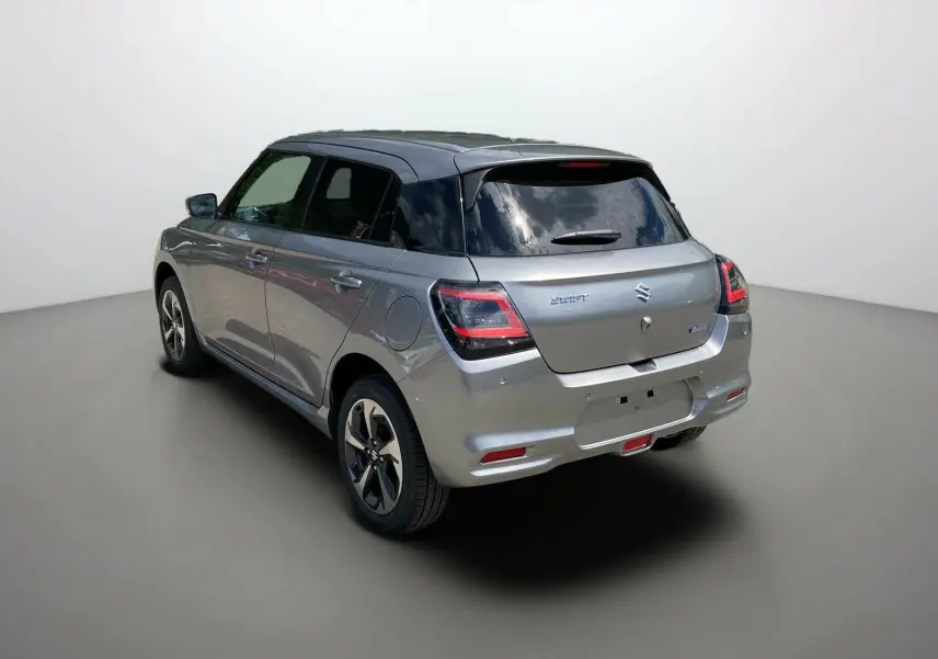 Vue 3/4 arrière droite d'une Suzuki Swift 2025 gris argent métallisé avec toit noir et vitres surteintées.