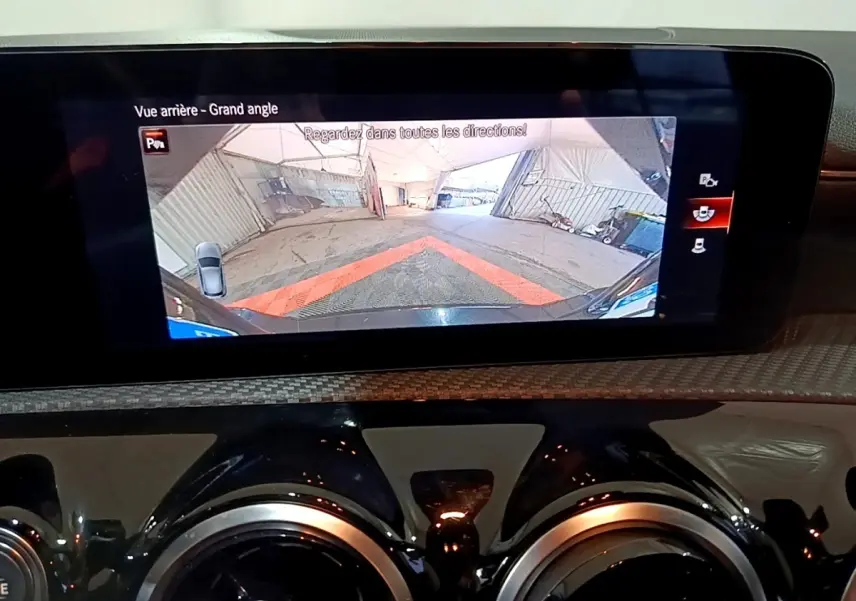 Écran tactile intérieur affichant la caméra de recul grand angle d'une Mercedes Classe A noire, vue arrière.