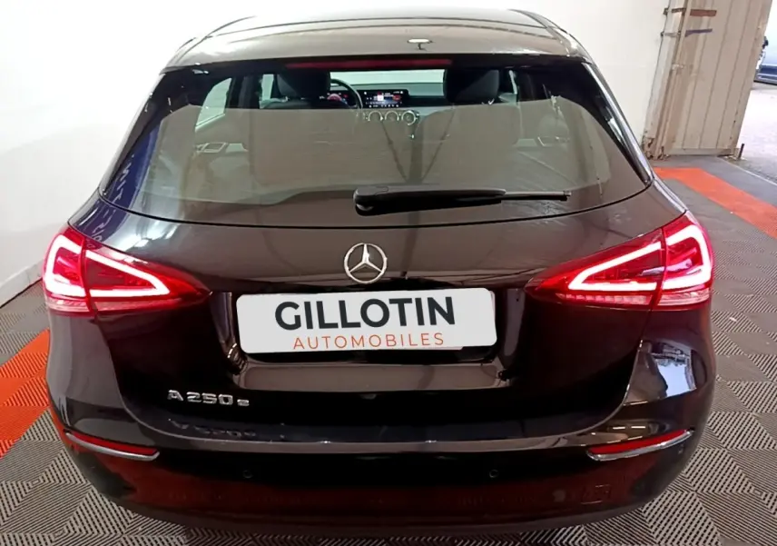 Vue arrière d'une Mercedes Classe A 250 e Business Line noire avec feux LED allumés en intérieur.