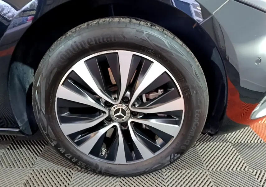 Gros plan sur la roue avant droite noire d'une Mercedes Classe A 250 e Business Line avec jante alliage bicolore.
