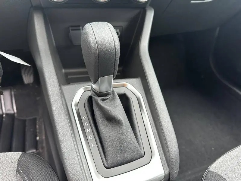 Gros plan sur le levier de vitesse noir de la Renault Clio 1.0 TCe 90ch Evolution 2025, intérieur gris et console centrale.