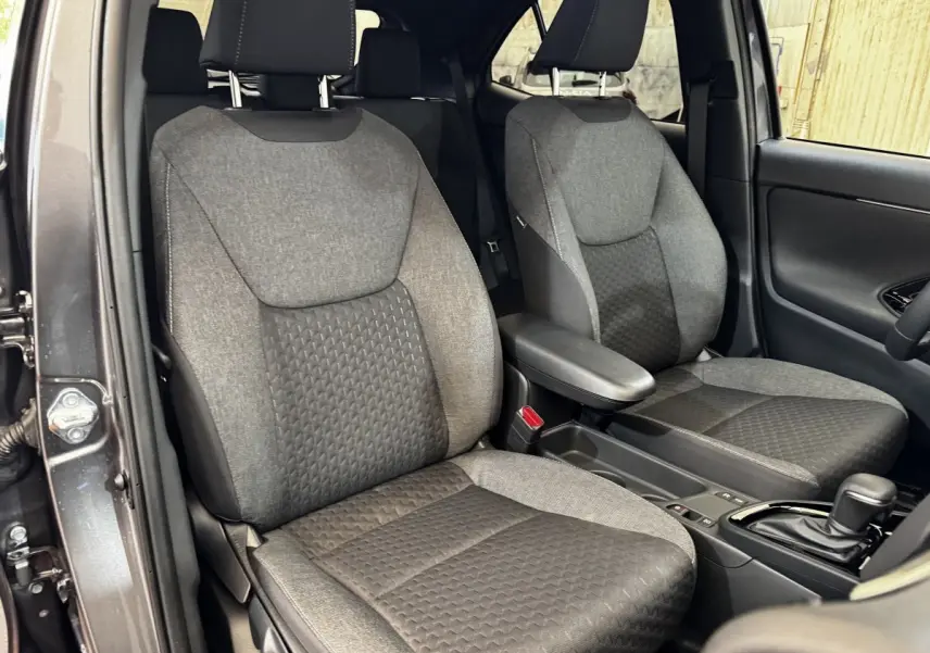 Vue intérieure côté avant droit de la Toyota Yaris Cross 2026, sièges tissu gris et console centrale avec boîte auto.