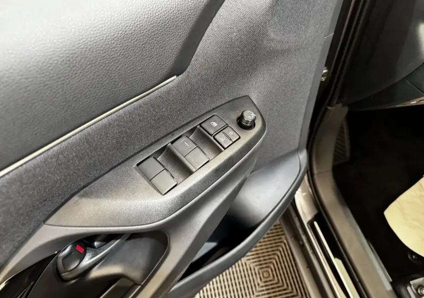 Gros plan sur la porte côté conducteur de la Toyota Yaris Cross 2026, montrant les commandes des vitres et rétroviseurs.