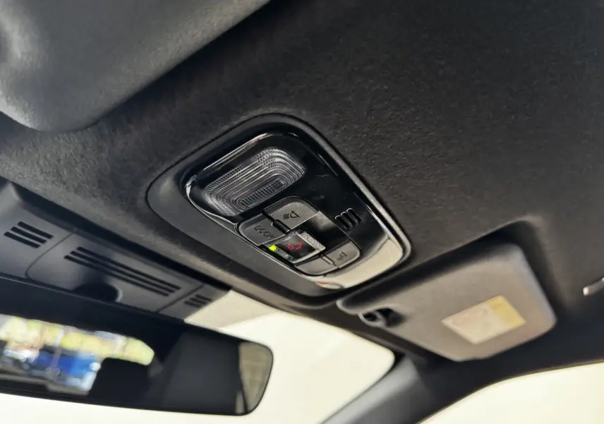 Détail du plafonnier intérieur noir avec commandes d’éclairage et d’alerte sur Toyota Yaris Cross gris foncé.