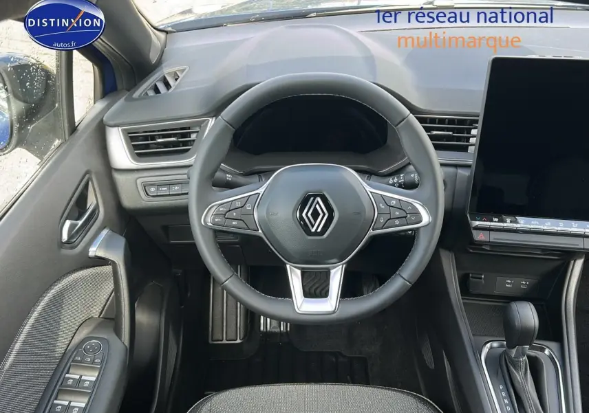 Vue intérieure centrée sur le volant multifonction Renault Captur 1.6 e-tech hybride avec écran tactile et levier de boîte auto.