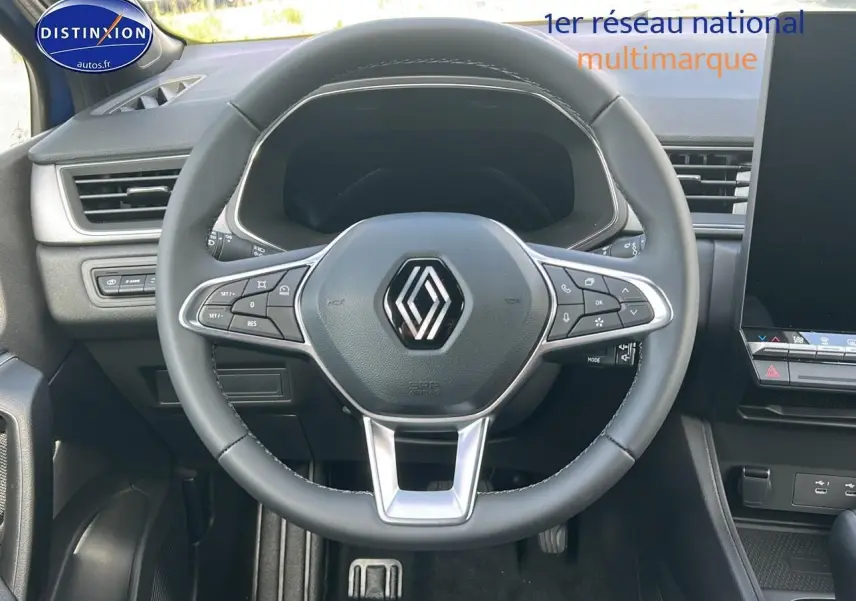 Vue intérieure centrée sur le volant multifonction noir du Renault Captur 2025 avec tableau de bord et écran tactile visible.