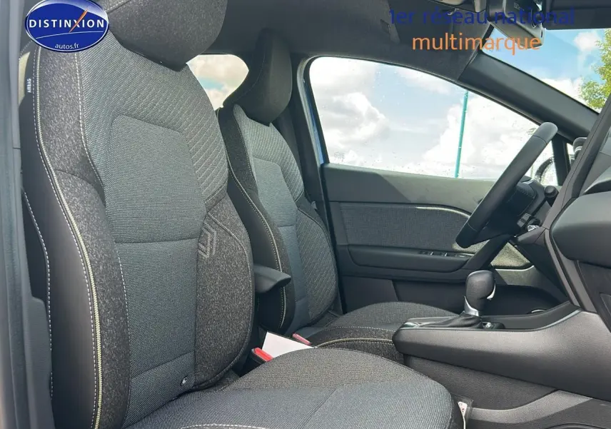 Intérieur avant du Renault Captur 1.6 e-tech hybride 2025, sièges gris avec accoudoir central et levier de boîte automatique.