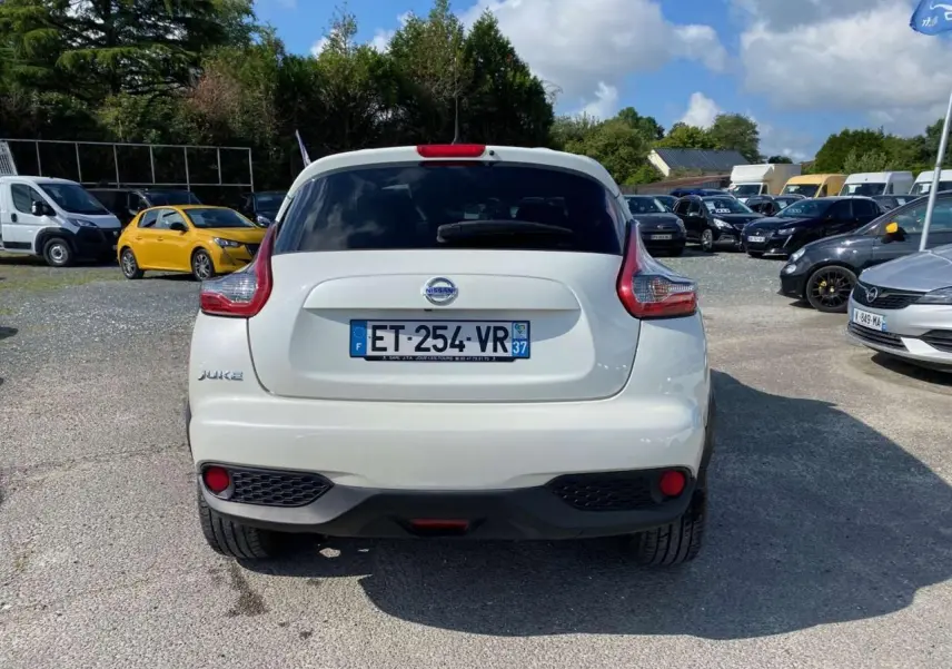 Vue arrière d'un Nissan Juke blanc 2017 avec feux arrière caractéristiques et lunette arrière surteintée.