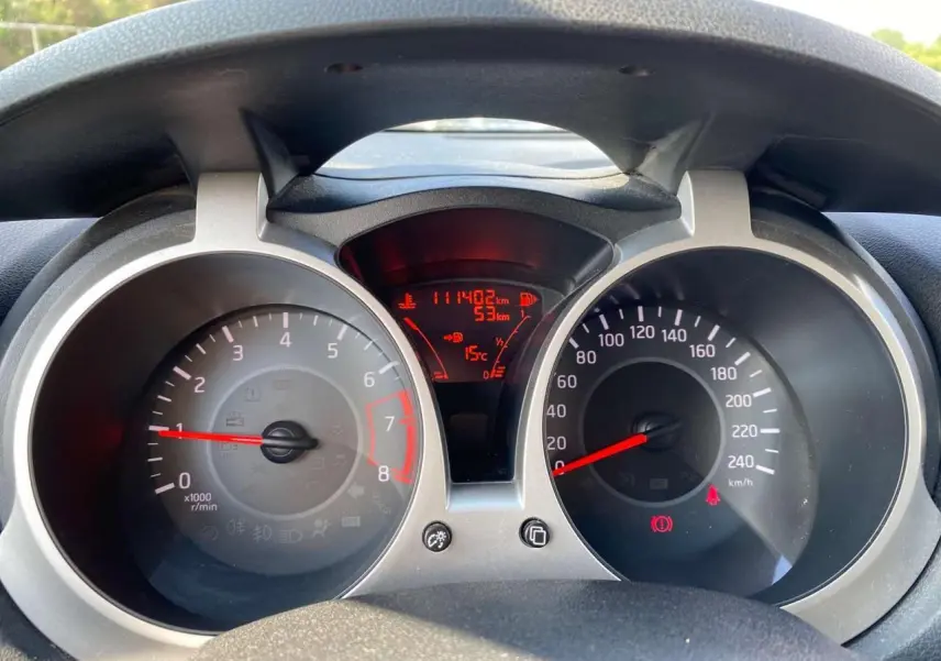 Tableau de bord du Nissan Juke blanc 2017 montrant compte-tours, compteur de vitesse et affichage digital central.