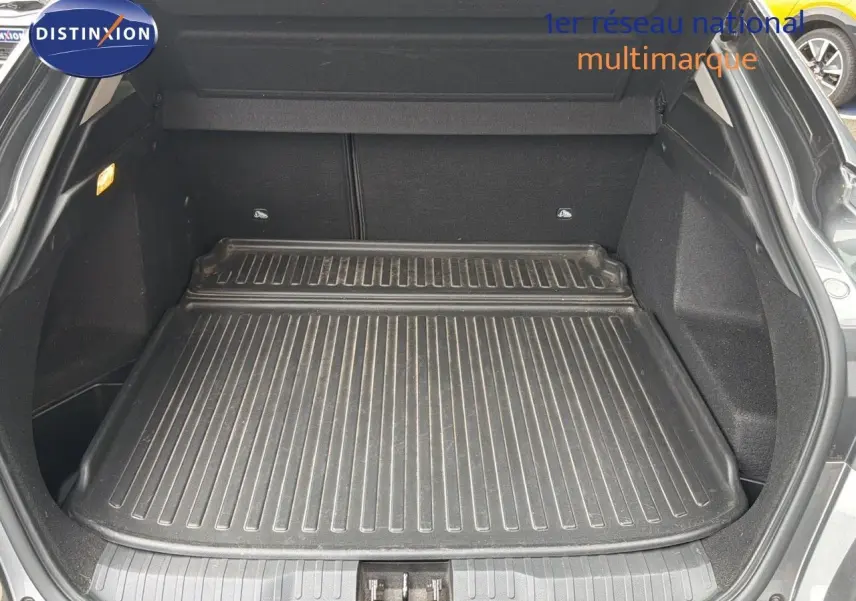 Coffre ouvert du Renault Arkana gris 2022, vue arrière montrant un tapis de protection noir dans le coffre spacieux.