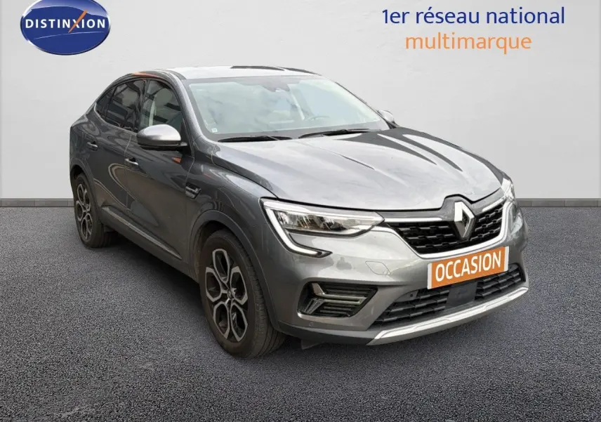 Renault Arkana gris 3/4 avant droit avec jantes bi-ton et calandre noire, sur fond neutre showroom.