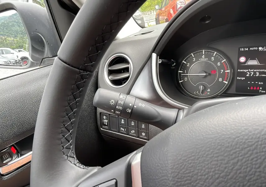 Vue intérieure côté conducteur du Suzuki Vitara 2025, tableau de bord avec compte-tours et commandes au volant en cuir noir.