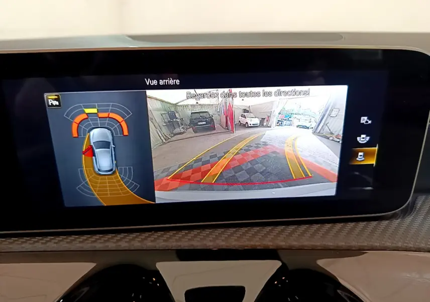 Écran tactile intérieur montrant la caméra de recul et l’aide au stationnement de la Mercedes Classe A gris clair.