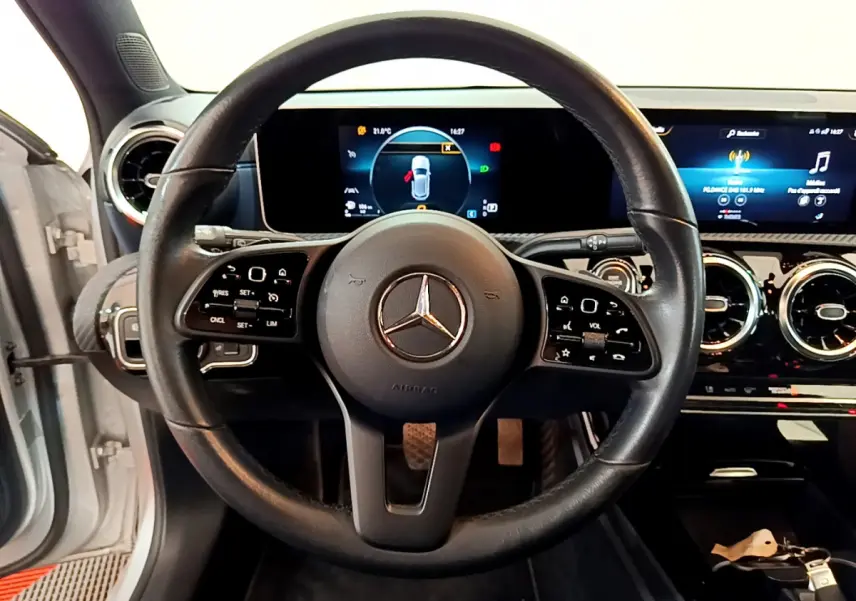 Vue intérieure centrée sur le volant cuir noir d’une Mercedes Classe A 180 d Business Line avec tableau de bord numérique.