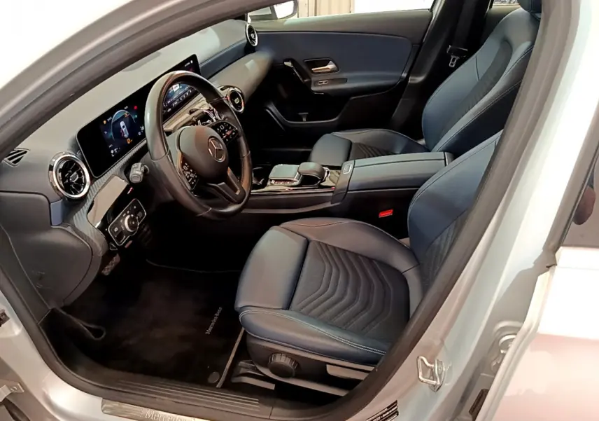 Vue intérieure côté conducteur de la Mercedes Classe A 180 d Business Line 2020, sièges noirs et tableau de bord digital.