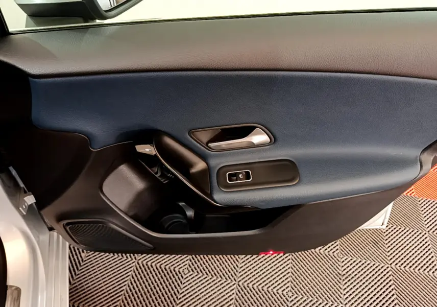 Vue rapprochée de la porte côté conducteur d’une Mercedes Classe A 180 d Business Line 2020 avec garniture bleu foncé et gris clair.