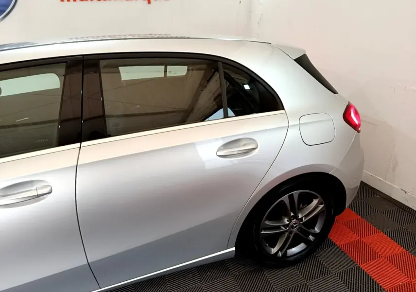 Vue latérale droite d'une Mercedes Classe A gris clair, mettant en valeur la porte arrière et la roue arrière avec jante alliage.