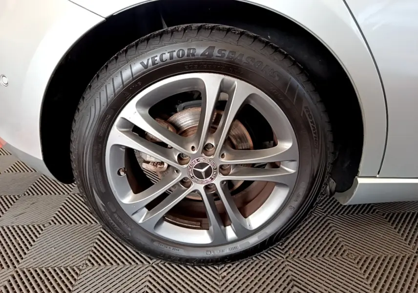 Gros plan sur la roue avant droite gris clair d'une Mercedes Classe A 180 d Business Line avec jante alliage cinq branches.