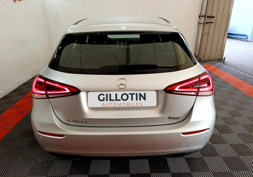 Vue arrière d'une Mercedes Classe A 180 d Business Line gris clair avec feux LED allumés dans un garage.