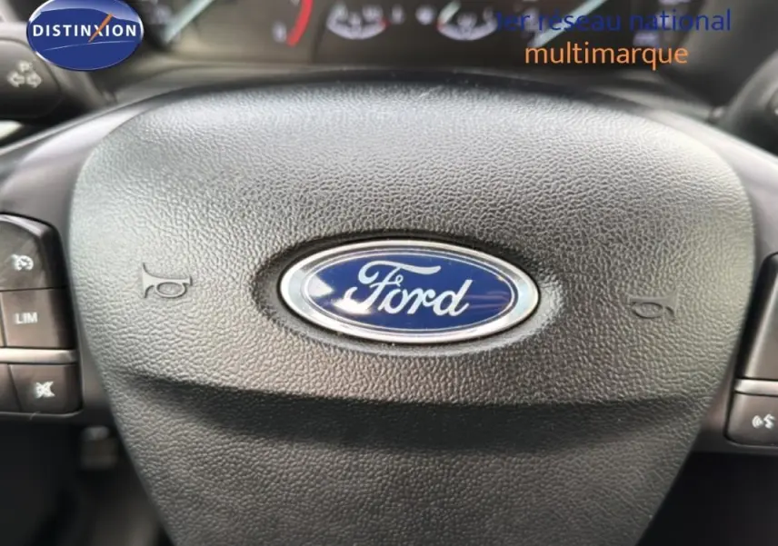 Gros plan sur le volant noir avec logo Ford au centre du Ford Puma blanc, version Titanium 2020.