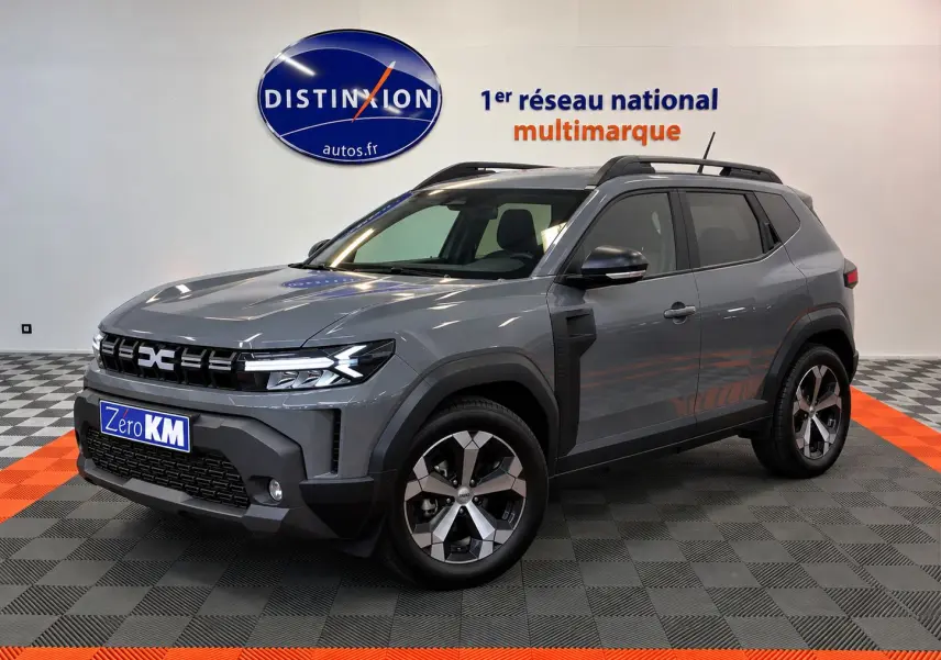 Dacia Duster 1.8 Full Hybride gris schiste en 3/4 avant droit, avec jantes alliage et calandre moderne.