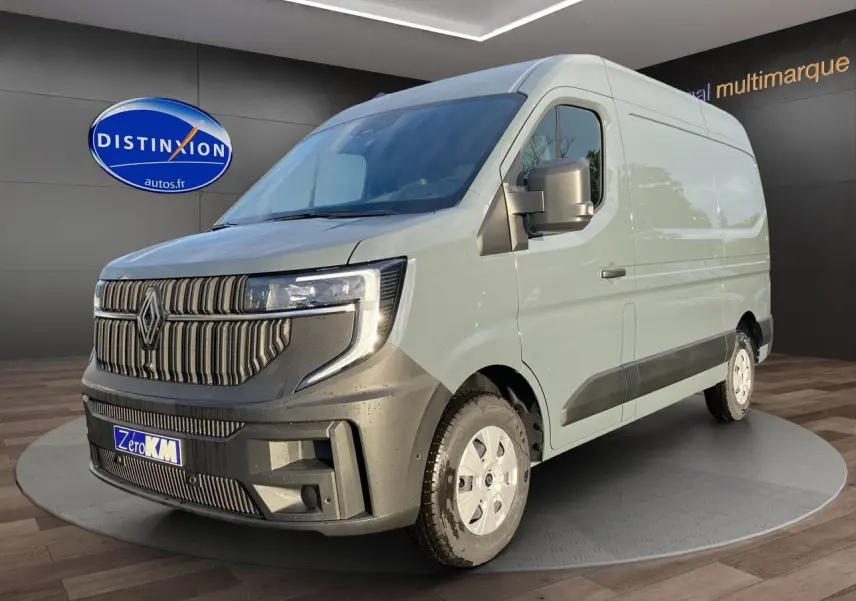 Renault Master gris urbain en 3/4 avant droit, avec calandre noire distinctive et roues blanches.