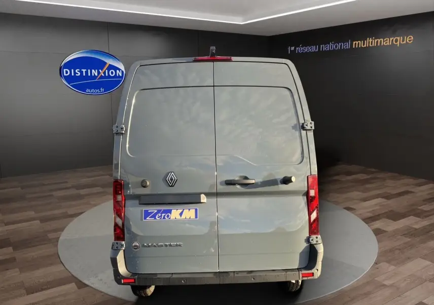 Vue arrière d'un Renault Master gris urbain 2025 avec portes arrière tôlées et feux rouges verticaux.