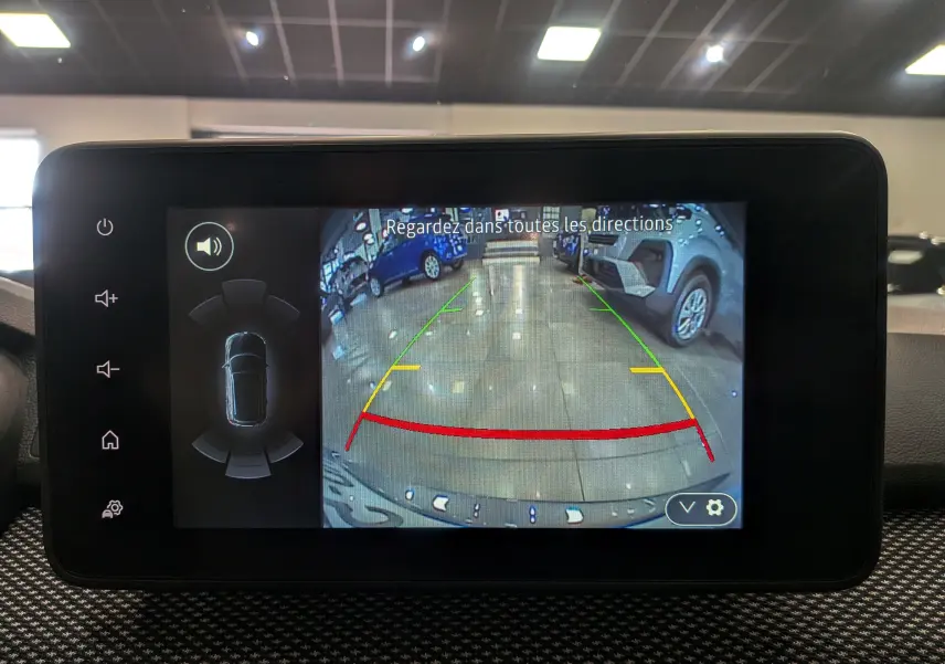 Écran central montrant la caméra de recul du Dacia Sandero gris schiste, avec lignes d’aide au stationnement colorées.