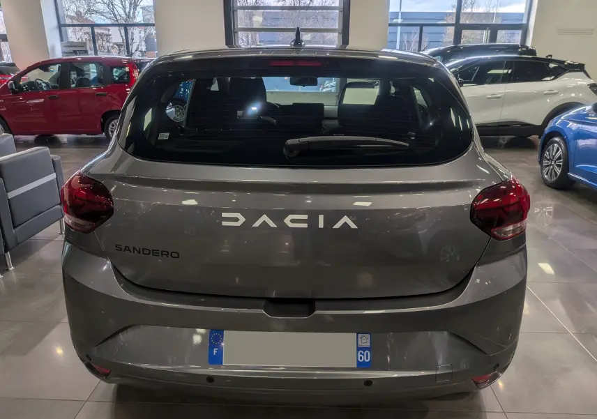 Vue arrière d'une Dacia Sandero TCe 90 CH Journey 2025 en gris schiste, avec feux arrière rouges et lunette arrière teintée.