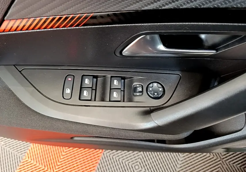 Gros plan sur la commande des vitres électriques et rétroviseurs côté conducteur d'une Peugeot 2008 blanche.